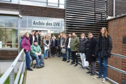 Foto: Studierende der Universität zu Köln stehen vor dem Eingang des Archivs