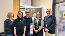 Foto von f&uuml;nf Personen vor einem Aufsteller