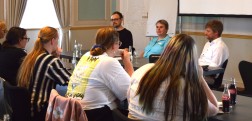 Das Foto zeigt Herrn Ries, Frau Marner und Herrn Lambertz nebeneinander an einem Tisch sitzend w&auml;hrend der Podiumsdiskussion zum Berufsfeld Archivar*in. Im Vordergrund sind die aufmerksam zuh&ouml;renden Studierenden von hinten zu sehen.