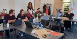 Auf dem Bild sind mehrere Menschen zu sehen, die auf Laptops gucken