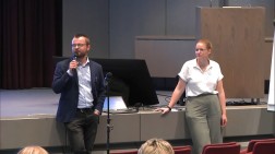Ein Mann und eine Frau tragen vor Publikum vor.